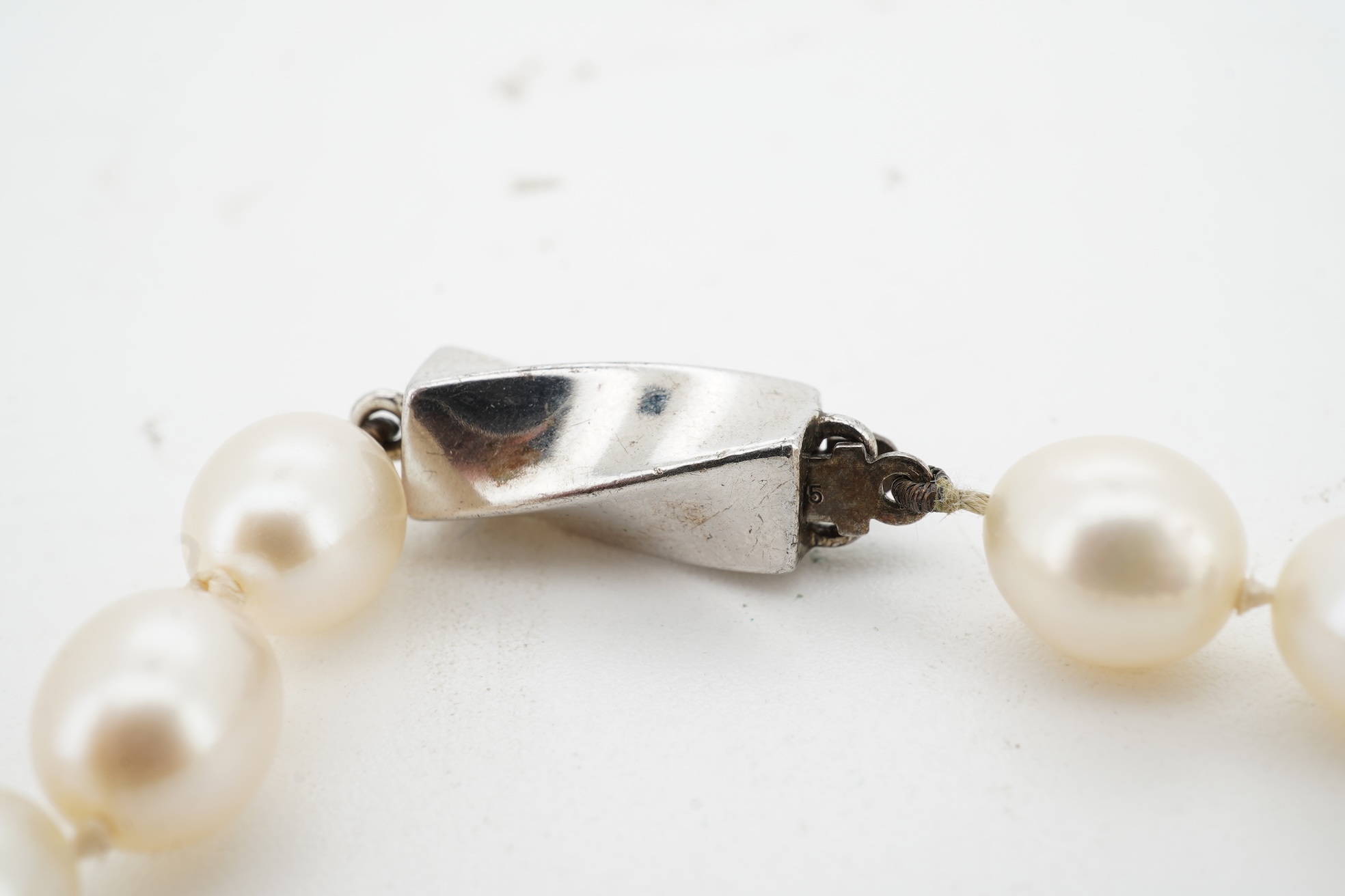 Tiffany & Co., a pair of diamond earrings and a cultured pearl necklace, the earrings of cross design, set with brilliant-cut diamonds totalling approximately 0.30 carats, mounted in platinum, length approximately 0.7cm